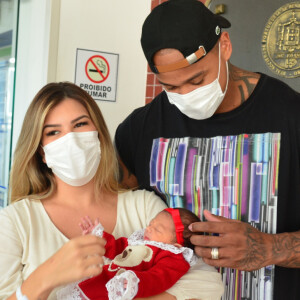 Filha de Lorena Improta e Leo Santana combinou vestido vermelho com laço e sapatinhos ao deixar hospital