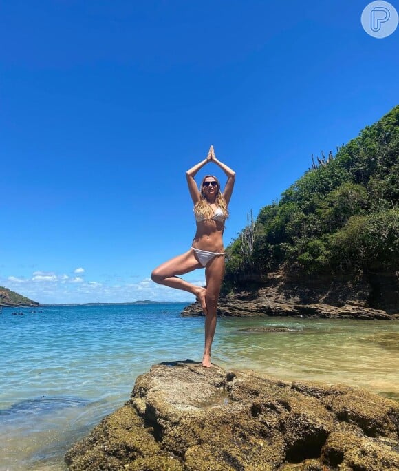 Monica Martelli escolheu biquíni branco de cintura baixa: a atriz fez pose de ioga em destino praiano
