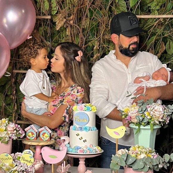 Biah Rodrigues usava uma presilha com laço cor de rosa, enquanto a pequena Fernando, que dormia no colo do pai, Sorocaba, usava uma faixa com laço branco