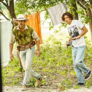 Jove (Jesuíta Barbosa) pede para Tadeu (José Loreto) posar perto à tapera de Juma (Alanis Guillen) na novela 'Pantanal'