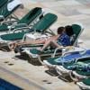 Selena Gomez toma sol na piscina do hotel Sheraton, no Rio de Janeiro, e desamarra a parte de cima do biquini tomara que caia para bronzear as costas
