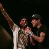 Neymar sobe no palco do show de Thiaguinho ao lado do surfista Gabriel Medina, em 28 de dezembro de 2014