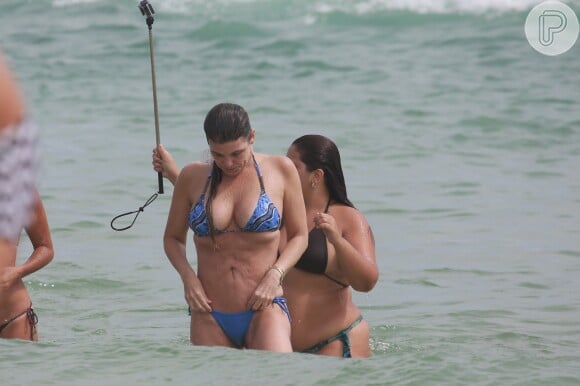 Cristiana Oliveira dá ajeitadinha no biquíni durante banho de mar