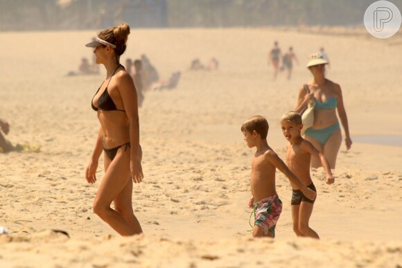 Filhos gêmeos de Fernanda Lima e Hilbert em fotos de 2014 se divertindo na praia com a mãe
