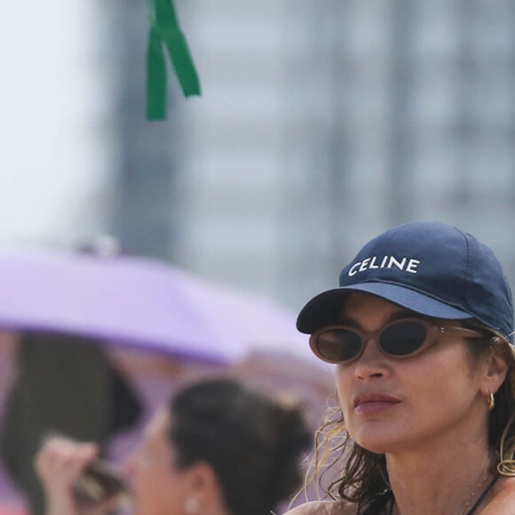 Flávia Alessandra não dispensou os óculos escuros na praia