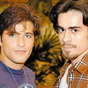 Na novela 'América', Junior (Bruno Gagliasso) e Zeca (Erom Cordeiro) tiveram beijo cortado no último capítulo
A partir do dia 27 de novembro, 'América' chega no Canal Viva em substituição à Senhora do Destino. A trama de Gloria Perez marcou o ano de 2005 com um enredo complexo, masque resultou em uma ótima média de 49 pontos de audiência.
Embora 'América' se tornou popular com bordões e personagens cativantes, para mantê-la até o final, a Rede Globo precisou fazer alguns justes, antes de sua estreia, e maioria durante sua exibição. 
Abaixo, a Purepeople traz as principais alterações da história de Sol (Deborah Secco) e sua turma:
Quais as principais reviravoltas de 'América'?

1. Mudança de abertura
Novela ensolarada com abertura sombria não combinava em 'América'. Para dar um ar mais rejuvenescedor, a equipe trocou a canção 'Orfãos do Paraíso, de Nilton Nascimento pela Soy Loco por ti América, na voz de Ivete Sangalo. 
A abertura mostrava os sonhos de Sol para chegar aos Estados Unidos e ao lado do seu amor, Tião (Murilo Benício). Na segunda abertura, as imagens ganharam um tom mais avermelhado. 
2. Mudança de atrizes
