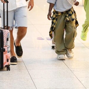 Filho de Bruno Gagliasso e Giovanna Ewbank, Bless aposta em aerolook composto por calça cargo verde-musgo, boné da mesma cor, camiseta cinza, tênis off-white e camisa xadrez amarrada na cintura