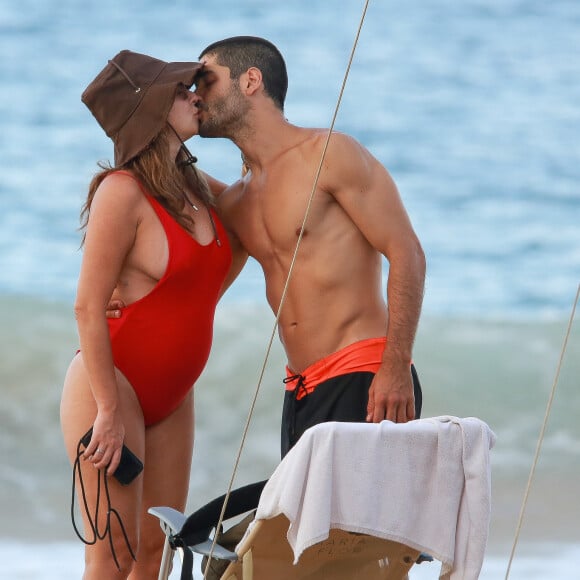 Fernanda Paes Leme, grávida de uma menina, e o noivo, Victor Sampaio, trocaram beijos em dia de praia