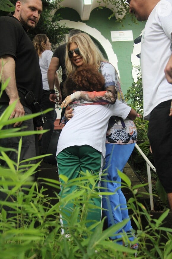 Fergie abraça uma das crianças da instituição