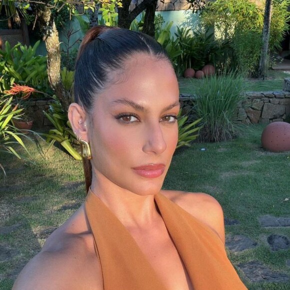 Mari Gonzales apostou em um vestido ousado em tons terrosos, com um decote gigante e as costas descobertas 