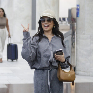 Juliette faz caras e bocas para fotógrafos em aeroporto do Rio