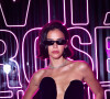 Bruna Marquezine dispensou alças e mangas no vestido preto com o qual surgiu no evento de moda em São Paulo e combinou a produção com óculos escuros