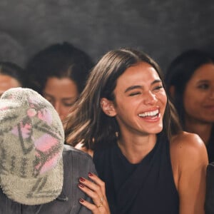 Sorrindo, Bruna Marquezine segura João Guilherme ao assistir o desfile da Mondepars