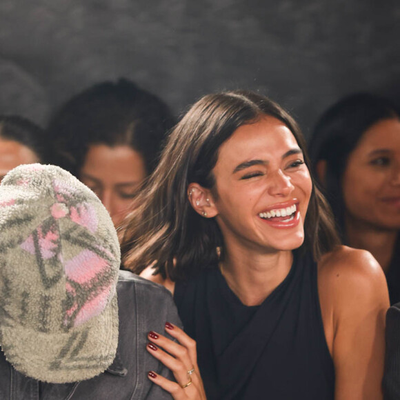 Sorrindo, Bruna Marquezine segura João Guilherme ao assistir o desfile da Mondepars