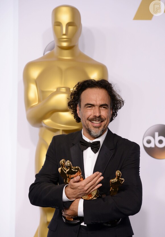 Alejandro Gonzalez Inarritu, vencedor da categoria Melhor Diretor, segura três das quatro estatuetas de 'Birdman'