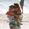 Angélica beija a filha Eva, de 2 anos, em passeio na praia neste domingo, ao lado de Luciano Huck.