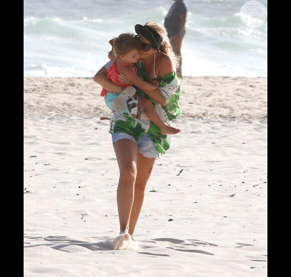 Angélica beija a filha Eva, de 2 anos, em passeio na praia neste domingo, ao lado de Luciano Huck.