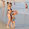 Rumores sobre a gravidez de Danielle Winits surgiram depois da atriz exibir uma barriguinha saliente na praia