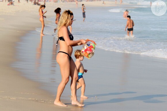 Rumores sobre a gravidez de Danielle Winits surgiram depois da atriz exibir uma barriguinha saliente na praia