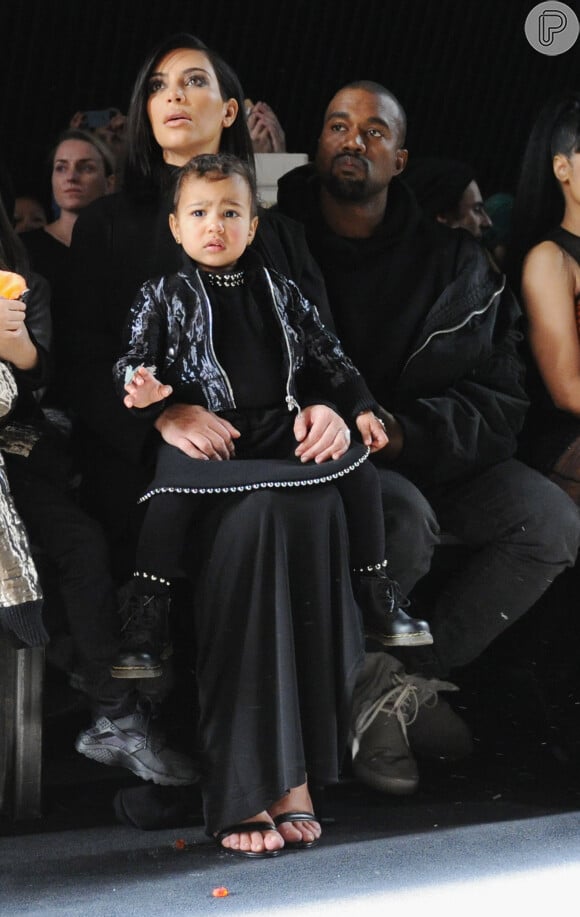 Kim Kardashian com North West no colo e ao lado do marido, Kanye West. A socialite revelou que a filha é viciada em sapatos
