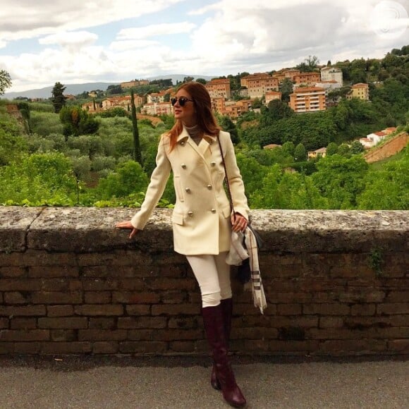 Em outro look com o par de botas, dessa vez em Siena, na Itália, Marina Ruy Barbosa apostou em calça e trench coat marfim. Ela ainda amarrou um lenço à bolsa, dando um ar fashion à composição