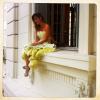 Giovanna Ewbank posa sentada em uma janela usando um vestido tomara que caia com babados