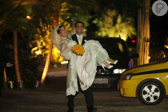 Delfino carrega a noiva no colo após deixar a igreja