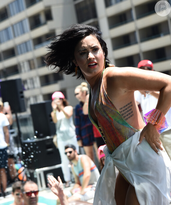 Demi Lovato leva tombo durante show em pool party: 'Nada legal para o verão', neste domingo, 5 de julho de 2015