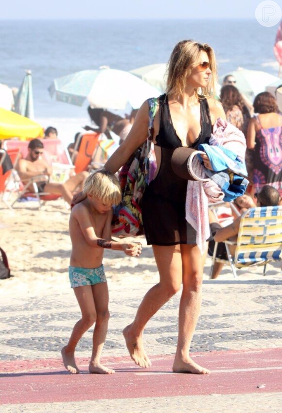 Após curtir o dia de sol e calor, Fernanda caminha em direção ao calçadão com o filho