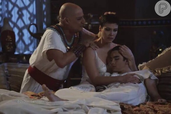 Nefertari (Camila Rodrigues) chora abraçada ao corpo do filho, Amenhotep (José Victor Pires), é é consolada pelo pai, Paser (Giuseppe Oristanio), após a 10ª praga, na novela 'Os Dez Mandamentos'