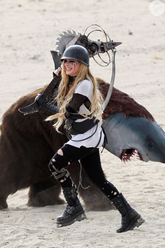 Avril Lavigne has some fun on day two of filming with a saw blade electric guitar on the set of Rock N Roll in Palmdale, Los Angeles, CA, USA on July 26, 2013. The sexy blond rocker chased around what appeared to be a bear shark with a mad max style guitar with a saw blade on it. She laughed as she charged the man in costume and even fell to the ground as she slipped in the sand. Photo by GSI/ABACAPRESS.COM27/07/2013 - Los Angeles