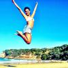 Paloma Bernardi mostra boa forma, fazendo salto na praia, de biquíni e shortinho