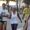 Gaby Amarantos caminha com os amigos na orla da praia de Ipanema, no Rio