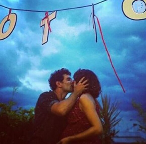 Sophie Charlotte e Daniel de Oliveira se beijam sob varal com nome do primeiro filho