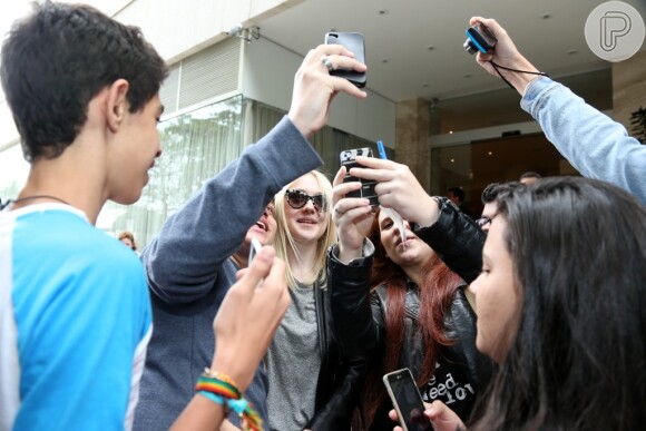 Dakota Fanning atende aos seus fãs na porta do hotel, minutos antes de deixar o Rio de Janeiro, neste domingo (29)