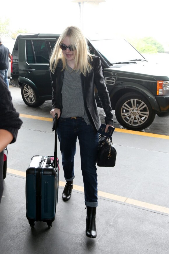 Dakota Fanning leva a própria mala para viajar de volta para os Estados Unidos, neste domingo (29)