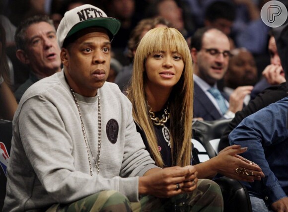 A diva Beyoncé e Jay-Z, concentrados, assistem à vitória da equipe preferida. O casal tem comprado muitos produtos de luxo caríssimos