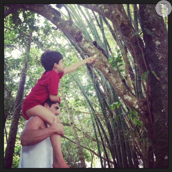 Na foto, Miguel, nos ombros de Marcus, olha micos na árvore