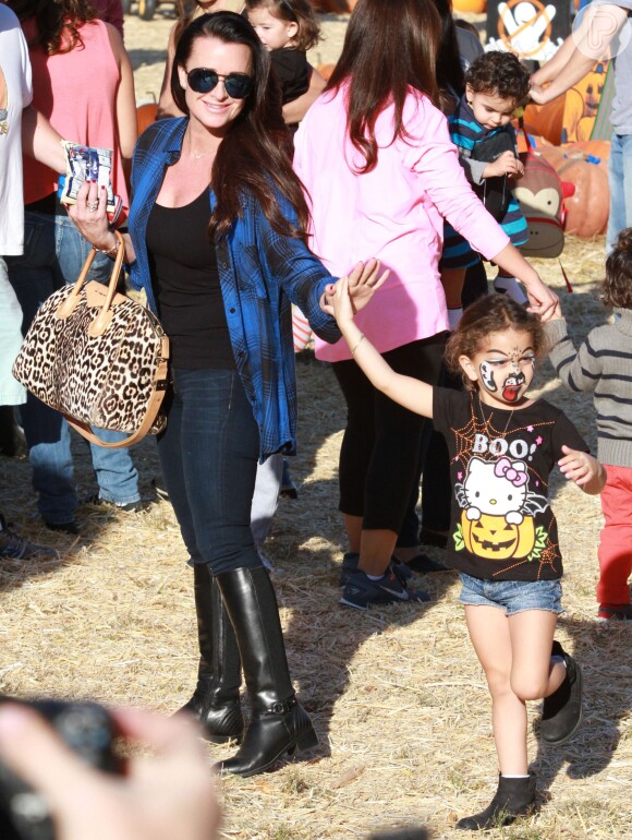 A atriz Kyle Richards vai a evento com uma das filhas, que tem o rosto pintado e uma blusa com o tema Halloween, em 12 de outubro de 2013