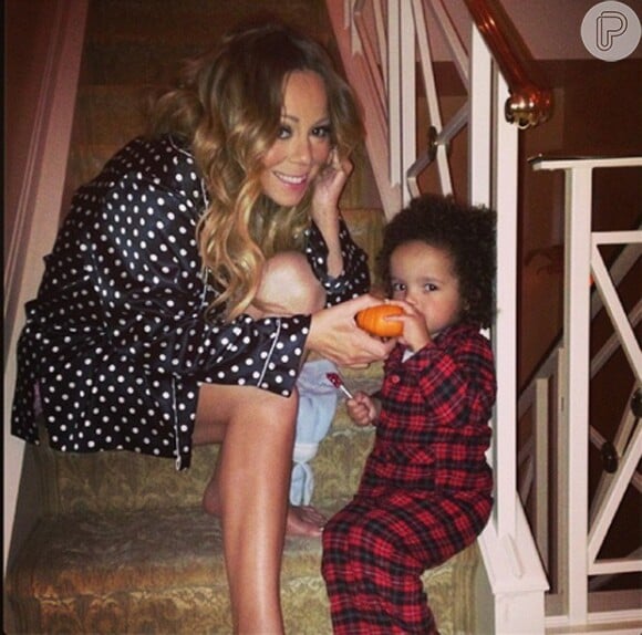 Mariah Carey ensina o filho, Moroccan, de 2 anos, a entrar no clima do Halloween. Na foto, a cantora dá uma abóbora ao menino