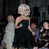 Lady Gaga não economizou em elementos conceituais para comparecer à edição de primavera/verão do London Fashion Week 2013. Ela escolheu botas de salto brilhantes e em verde oliva, como o vestido rodado, e uma meia calça com um tom mais claro da cor, com estampa tribal. Para fechar o look, nada como um adereço de flores, que cobriu até o queixo da cantora, no evento em Londres, que aconteceu em setembro de 2013