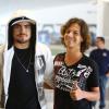 Caio Castro posa com fã no aeroporto do Rio