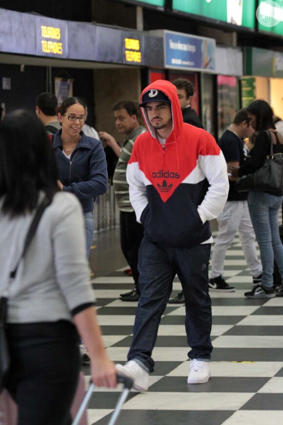 Caio Castro caminha pelo aeroporto parecendo estar mal-humorado