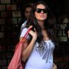 Daniella Sarahyba, grávida de uma menina, faz carinho na barriga na saída de restaurante carioca, em 11 de novembro de 2013