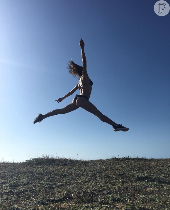 Isis Valverde postou uma foto só de biquíni dando um salto no ar