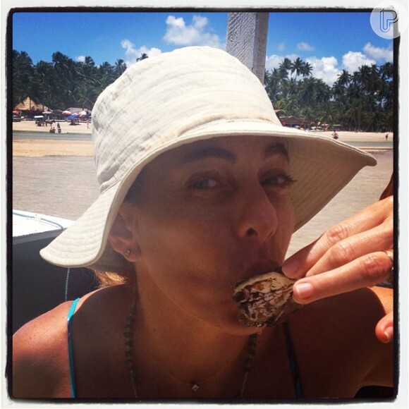Cissa Guimarães aproveitou o feriado na praia para saborear uma ostra, nesta sexta-feira, 15 de novembro de 2013