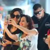 Anitta posa rodeada de fãs ao embarcar no Rio