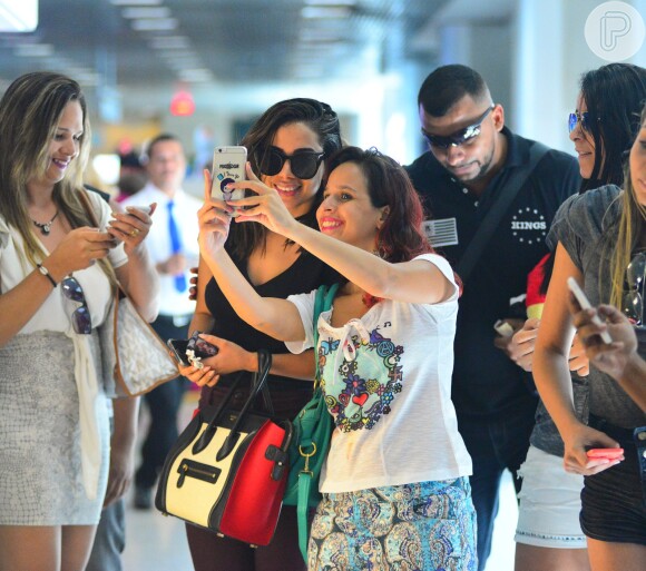 Anitta posa rodeada de fãs ao embarcar no Rio
