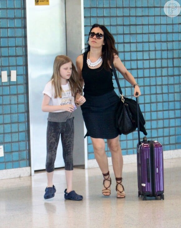 Alessandra Negrini chega apressada ao aeroporto com a filha, Bettina