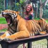 A atriz Marina Ruy Barbosa posou ao lado de tigres durante férias com o noivo, Xandinho Negrão, na Tailândia